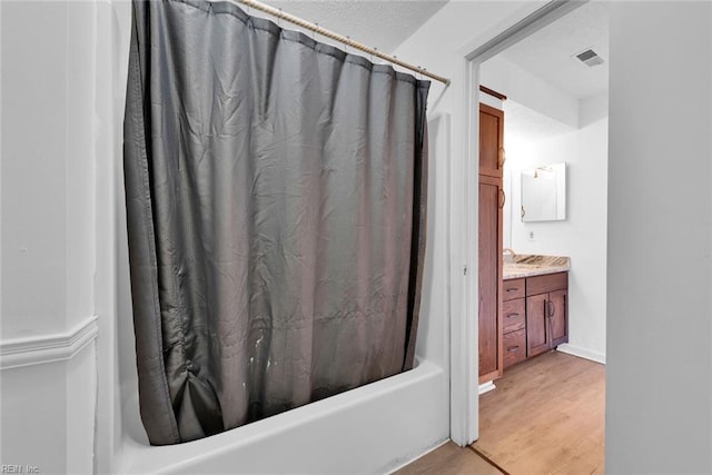 bathroom featuring vanity, shower / tub combo, and hardwood / wood-style flooring