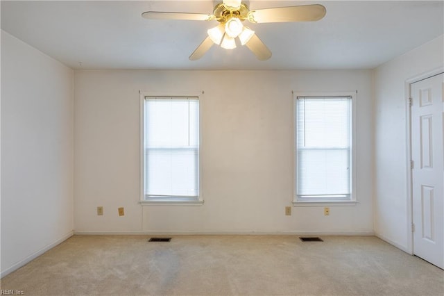 carpeted spare room with ceiling fan and a healthy amount of sunlight