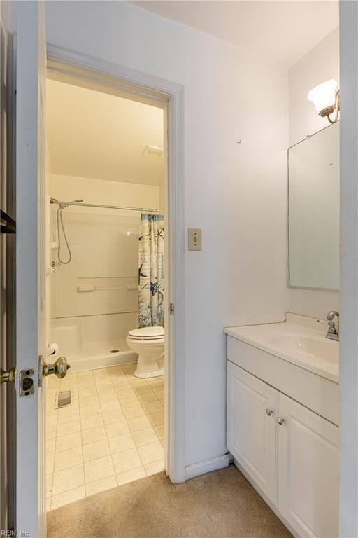 bathroom featuring a shower with curtain, tile patterned flooring, vanity, and toilet