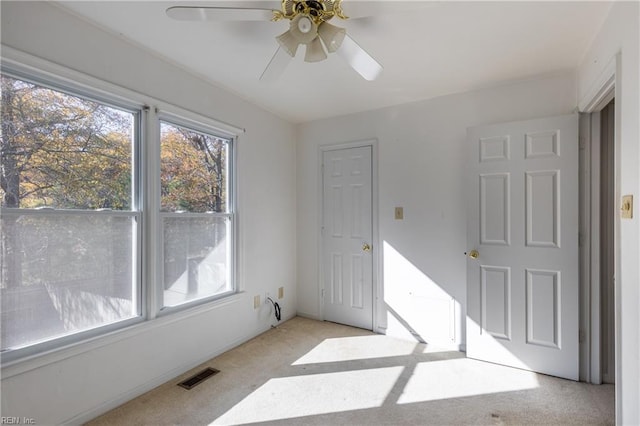 carpeted spare room featuring ceiling fan