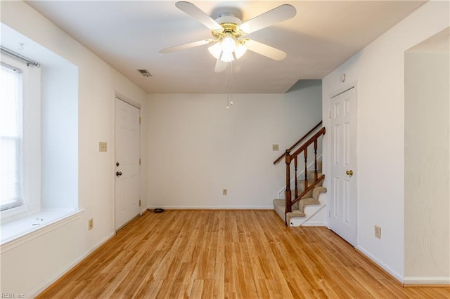 foyer entrance with ceiling fan and light hardwood / wood-style floors