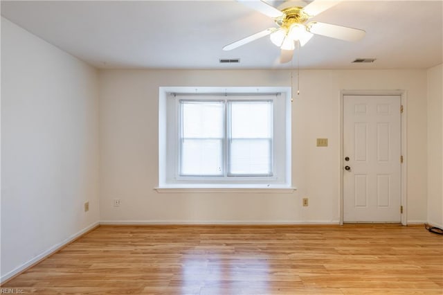 empty room with ceiling fan and light hardwood / wood-style flooring