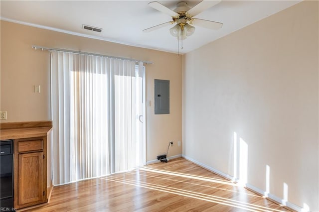 interior space with electric panel, ceiling fan, and light hardwood / wood-style flooring