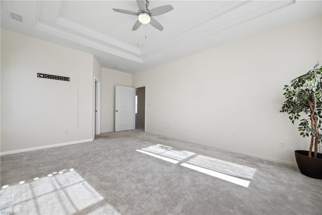 unfurnished bedroom featuring light colored carpet, ceiling fan, and a tray ceiling