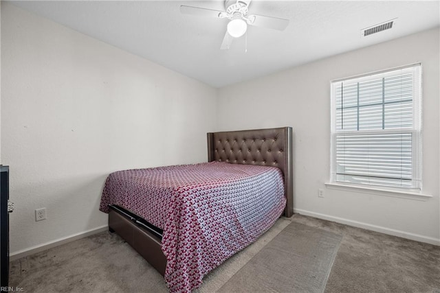 bedroom featuring carpet, ceiling fan, and multiple windows