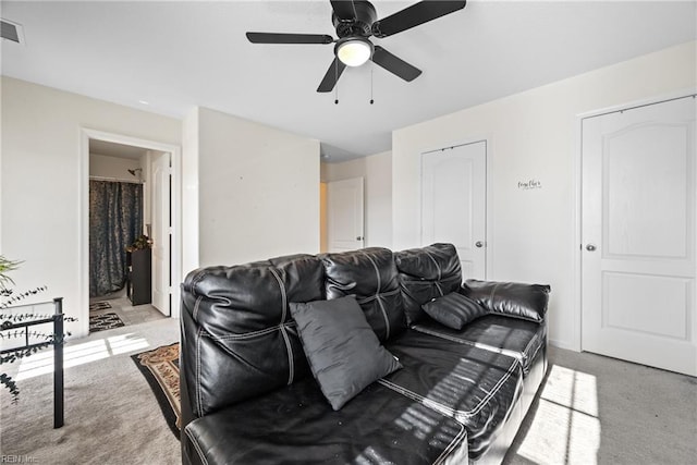 carpeted living room with ceiling fan