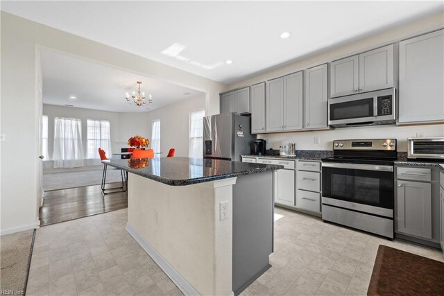 kitchen featuring a kitchen island, stainless steel appliances, and an inviting chandelier