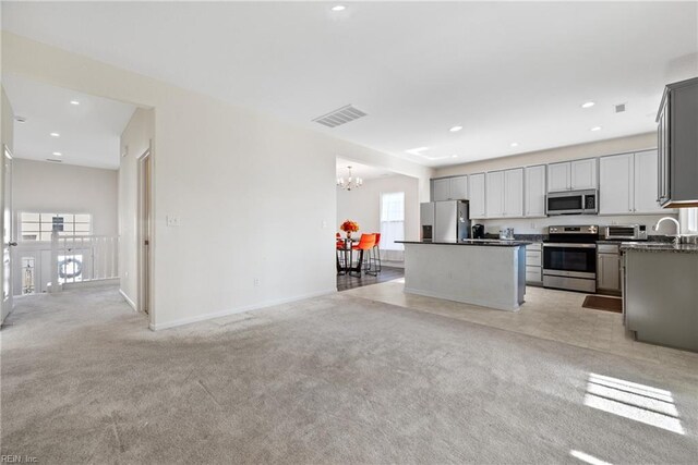 kitchen featuring gray cabinetry, plenty of natural light, a kitchen island, and stainless steel appliances