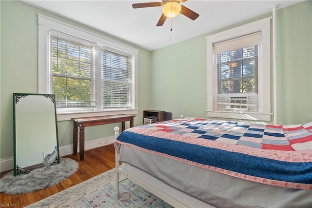 bedroom featuring wood-type flooring, multiple windows, and ceiling fan