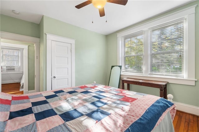 bedroom with ceiling fan, a closet, cooling unit, and hardwood / wood-style flooring