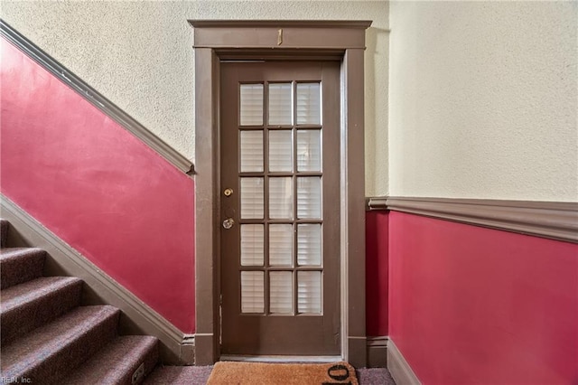 doorway featuring dark colored carpet