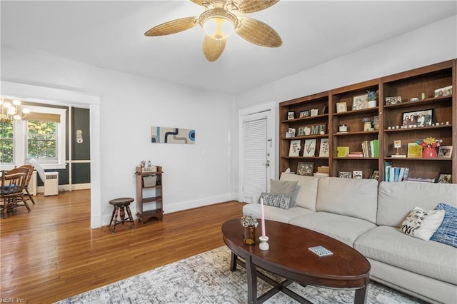 living room with ceiling fan with notable chandelier, wood-type flooring, and radiator