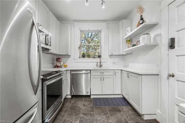 kitchen featuring stainless steel appliances, white cabinetry, and sink