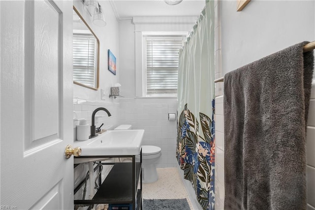 bathroom featuring sink, tile walls, and toilet