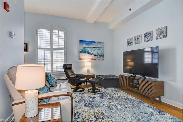 sitting room featuring beam ceiling and hardwood / wood-style floors