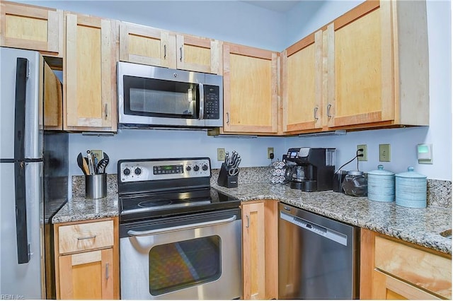 kitchen featuring light stone countertops, light brown cabinets, and stainless steel appliances