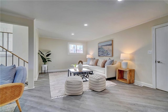 living room with light hardwood / wood-style floors and ornamental molding