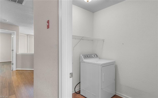 clothes washing area with wood-type flooring and washer / clothes dryer