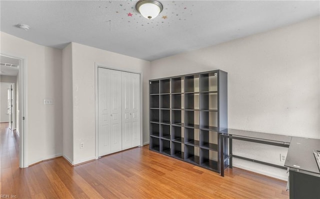 unfurnished bedroom with a closet and hardwood / wood-style flooring