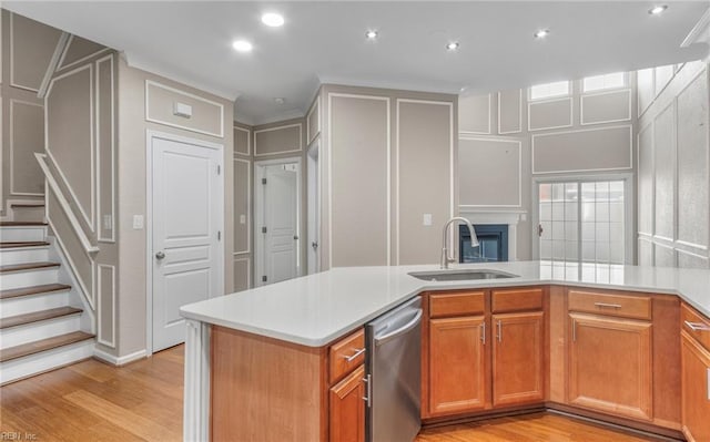 kitchen with kitchen peninsula, dishwasher, sink, and light hardwood / wood-style floors