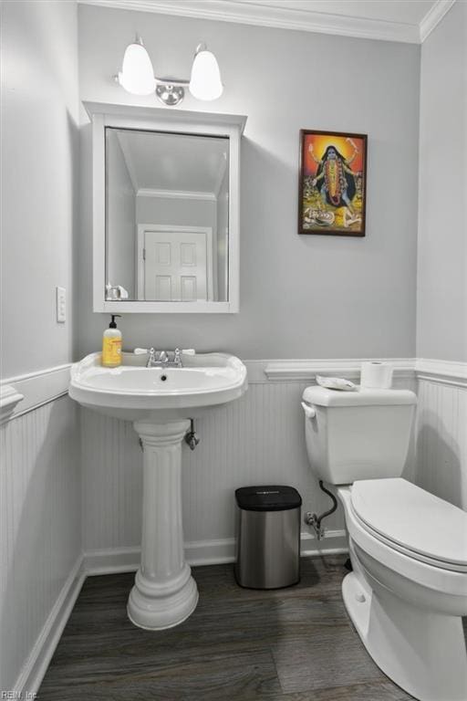 bathroom featuring toilet, wood-type flooring, and ornamental molding