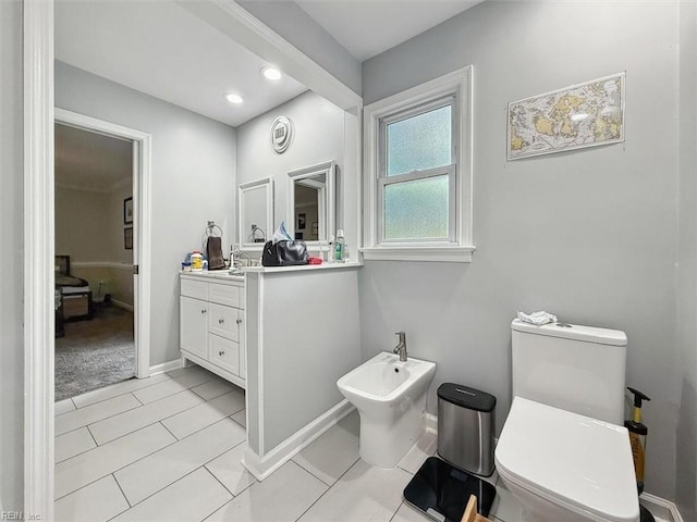 bathroom with tile patterned flooring, a bidet, vanity, and toilet