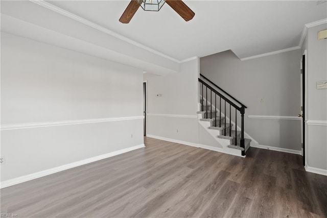 unfurnished living room featuring ceiling fan, wood-type flooring, and ornamental molding