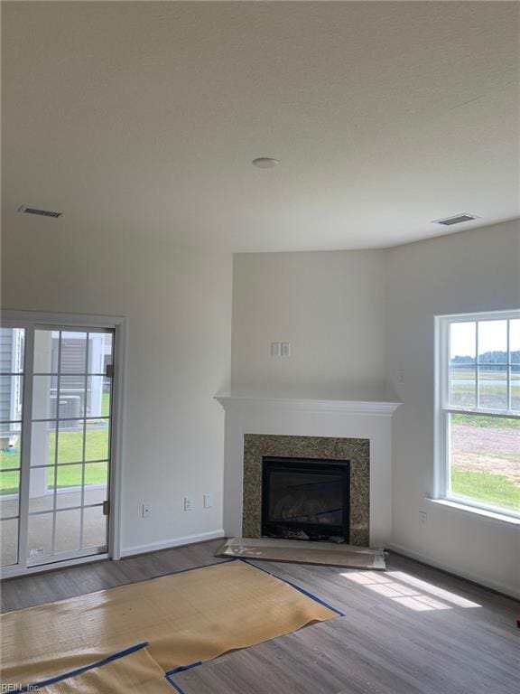 unfurnished living room featuring a high end fireplace and wood-type flooring