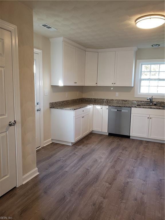 kitchen featuring wood-type flooring, white cabinetry, stainless steel dishwasher, and sink