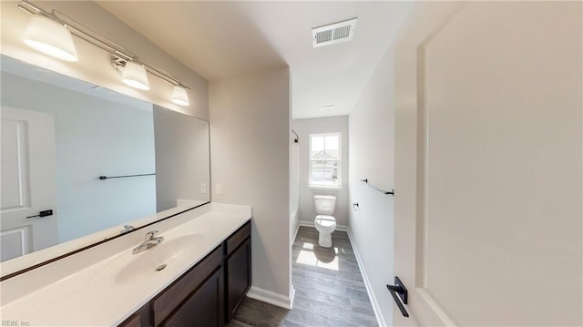 bathroom featuring hardwood / wood-style flooring, vanity, and toilet