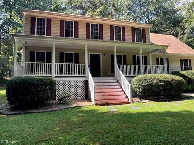 colonial-style house featuring covered porch and a front yard