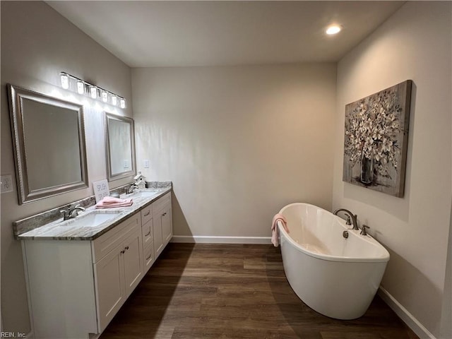 bathroom featuring hardwood / wood-style floors, vanity, and a bath