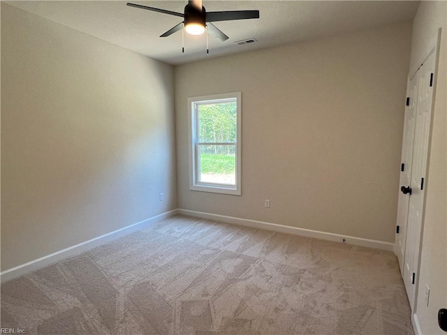 carpeted empty room featuring ceiling fan