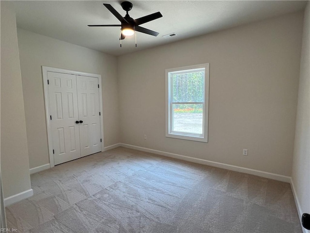 carpeted spare room featuring ceiling fan