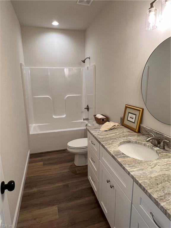 full bathroom featuring bathtub / shower combination, hardwood / wood-style floors, vanity, and toilet