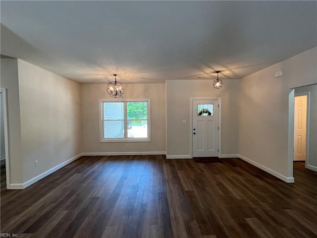 foyer entrance featuring dark hardwood / wood-style floors and an inviting chandelier