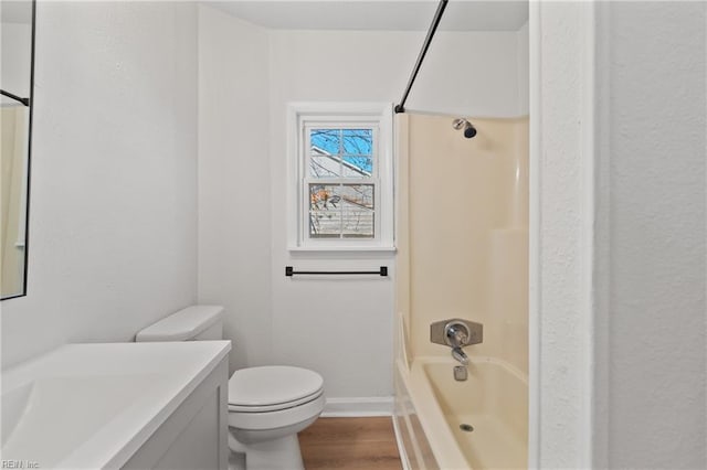 full bathroom featuring hardwood / wood-style floors, vanity, toilet, and bathtub / shower combination