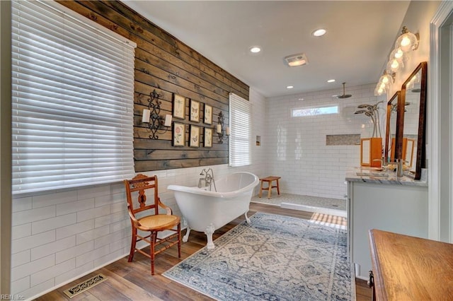 sitting room with hardwood / wood-style floors and tile walls