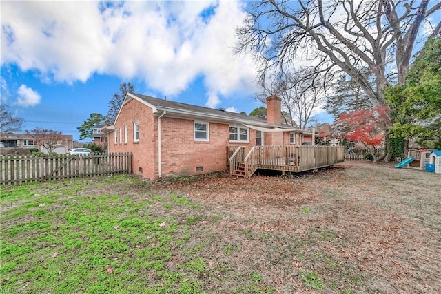 back of property with a lawn and a wooden deck