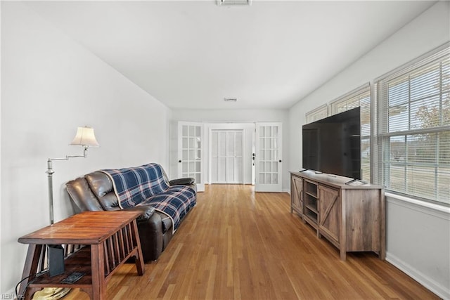 living room featuring french doors and light hardwood / wood-style floors