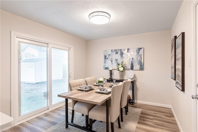 dining room featuring hardwood / wood-style floors and a textured ceiling