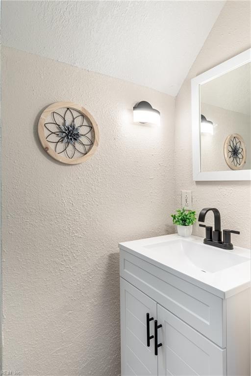 bathroom with vanity and lofted ceiling