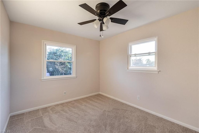 carpeted spare room with ceiling fan