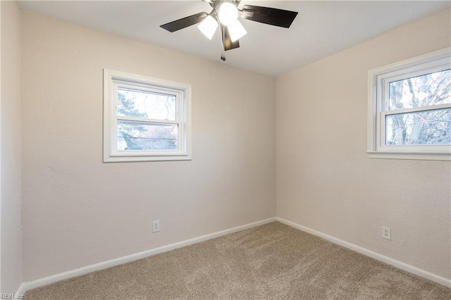 empty room featuring carpet flooring, a wealth of natural light, and ceiling fan