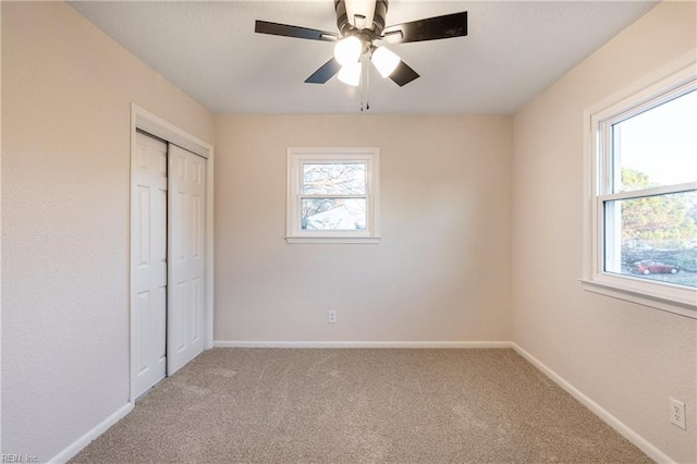 unfurnished bedroom with ceiling fan, carpet floors, and a closet