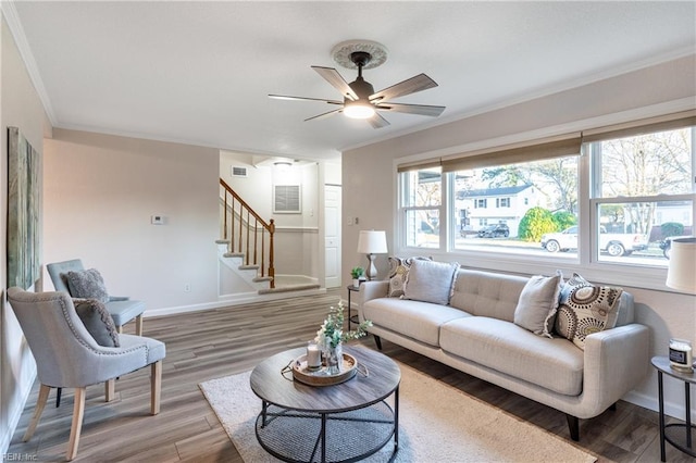 living room featuring wood-type flooring, ceiling fan, and crown molding