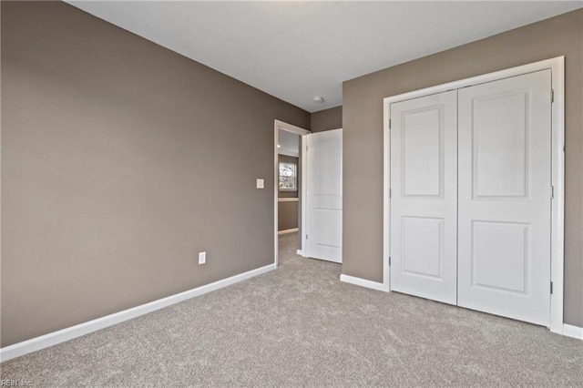 unfurnished bedroom featuring a closet and light colored carpet