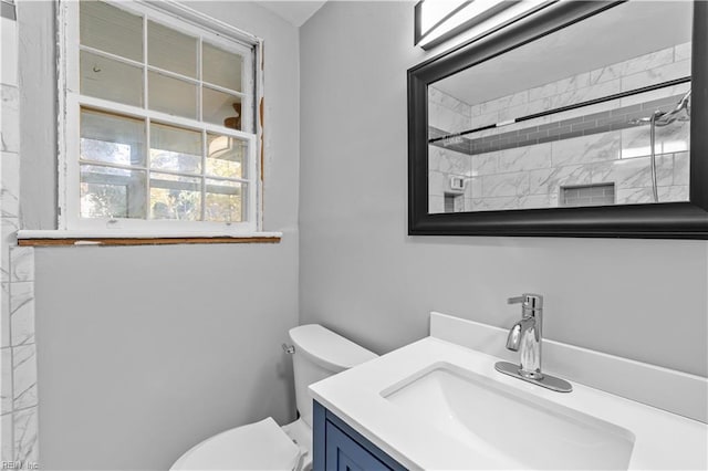 bathroom featuring vanity, toilet, and tiled shower