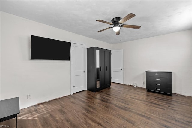 unfurnished bedroom with dark hardwood / wood-style flooring and ceiling fan