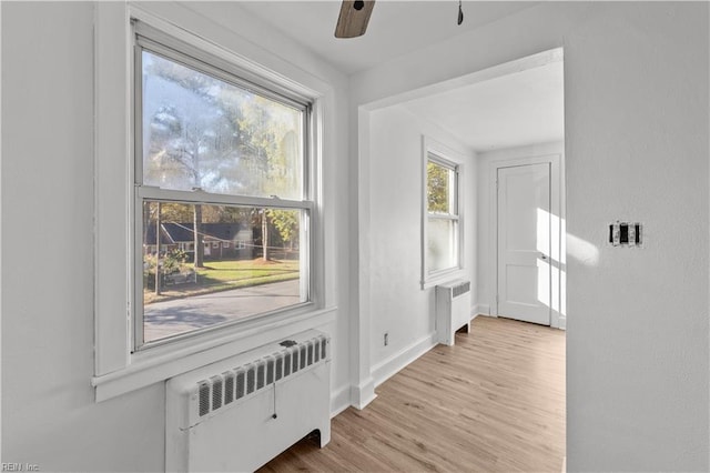 foyer entrance featuring radiator, ceiling fan, and light hardwood / wood-style floors